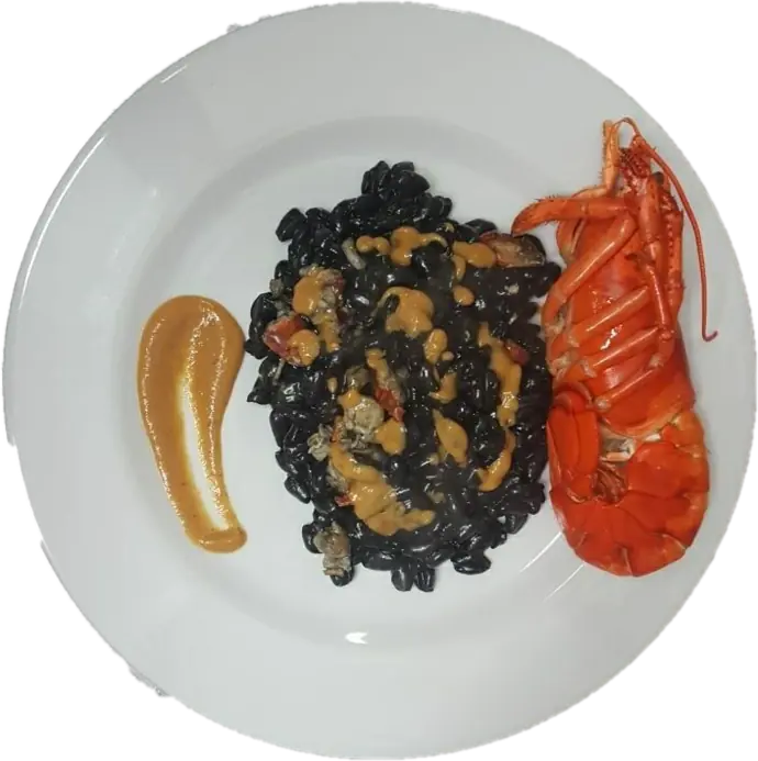 Piatto bianco con pasta al nero e mezzo crostaceo rosso